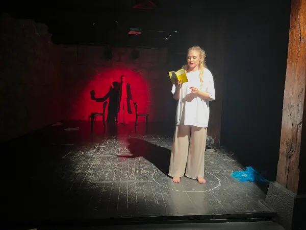 Acting Core Programm der Filmschauspielschule Zürich: Schauspielerin bei intensiver Szenenarbeit auf dunkler Bühne mit dramatischem Licht